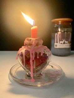 a candle that is on top of a glass bowl with some food in the middle