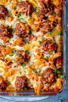 a green casserole dish filled with pasta and meat covered in marinara sauce