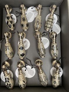 an assortment of decorative vases in a box with tags on the handles and sides