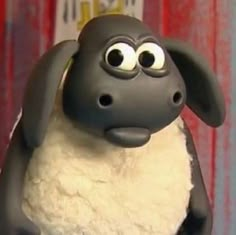 a close up of a toy sheep with big eyes