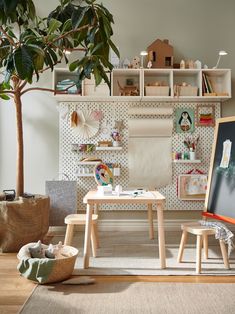 a child's playroom with toys and artwork on the wall, including a tree