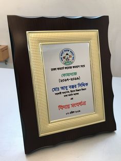 an award plaque is placed in front of a white table with a black frame and writing on it