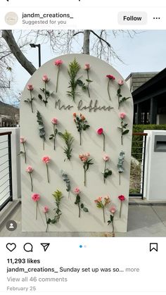 flowers are arranged on the side of a white sign that says, i love you