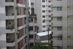 an apartment building with balconies in the foreground and other buildings in the background