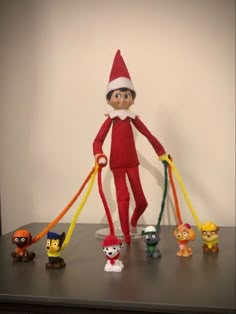 an elf with five small toys on a table