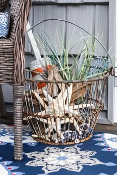 a basket filled with plants sitting on top of a blue rug next to a wicker chair