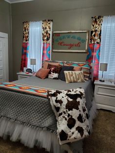 a bedroom with a cow print blanket on the bed