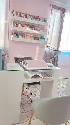 a room with a desk, chair and shelves filled with nail polish