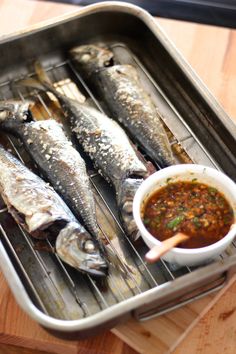 some fish are cooking on a grill with sauce