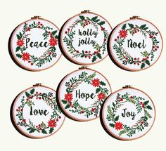 four embroidered christmas ornaments with the words peace, holly and noel on them in red and green