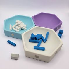 three different shapes and sizes of plastic objects on a white surface with blue, purple, and grey ones