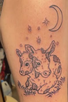 a tattoo with two cows on it and the moon in the sky above them, as well as stars