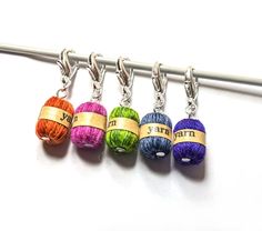 four balls of yarn are hanging from a hook