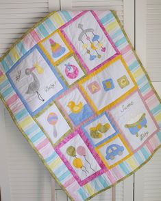 a baby quilt hanging from the side of a door