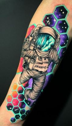 an astronaut tattoo on the arm with space and stars in the background, as well as he