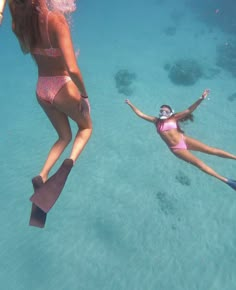 two women in bikinis are diving and having fun