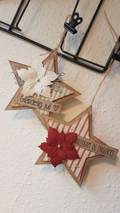 three wooden stars hanging from the ceiling with red and white decorations attached to each star