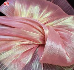 a pink and yellow flower on top of a black surface