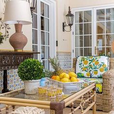 a living room filled with lots of furniture next to a table covered in lemons