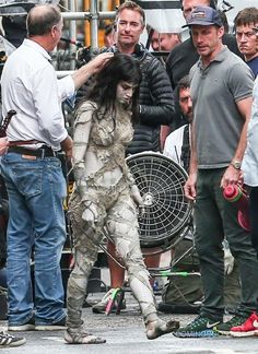 the woman is getting her hair done while other people look on in front of him