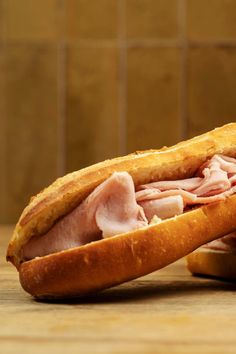 a ham and cheese sandwich sitting on top of a wooden table