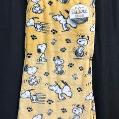 a yellow shirt with black and white snoopy dogs on it's chest is shown