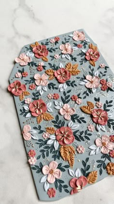 a close up of a flowered place mat on a table with marble counter top