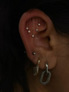 a woman's ear with three different piercings attached to the side of her ear