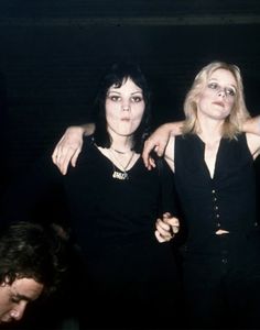 two women standing next to each other with their arms around one woman's shoulders