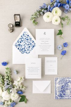 the wedding stationery is laid out with blue and white flowers