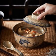 a person is stirring some food in a bowl with spoons and chopsticks