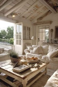 a living room filled with white furniture and lots of windows