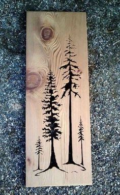 a wooden plaque with some trees on it