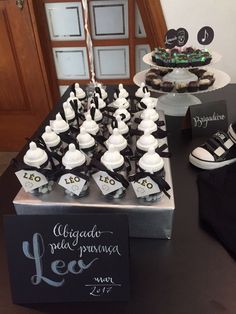 a table topped with lots of cupcakes covered in white frosting