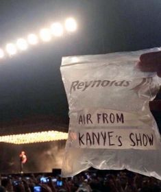 someone holding up a plastic bag with the words air from kanye's show written on it