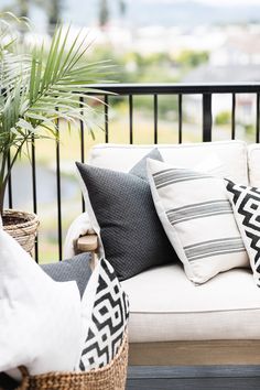 a white couch sitting on top of a wooden floor next to a potted plant