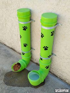 a pair of green boots with paw prints on them and a dog food dish in the bottom