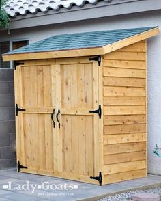 a wooden storage shed sitting next to a building