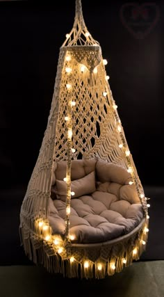 a hammock with lights hanging from it's sides and pillows on the bottom