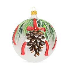 a glass ornament with pine cones and red ribbon on it's side