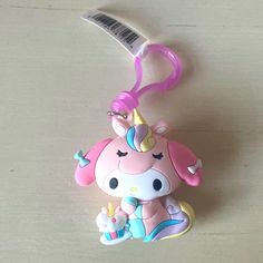 a little pink unicorn keychain with a toothbrush in it's mouth