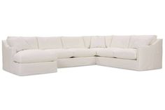 a white sectional couch sitting on top of a white floor