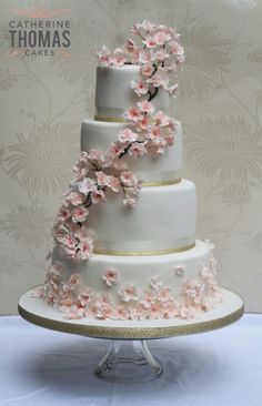 a three tiered wedding cake with pink flowers on it