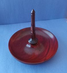 a wooden pen holder with a metal tip in it on a blue tablecloth background