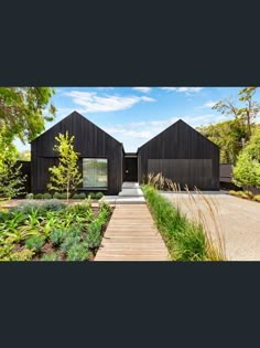 a black house with wooden walkway leading to it