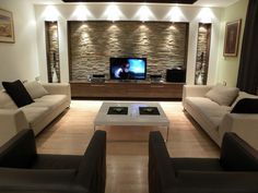 a living room filled with furniture and a flat screen tv mounted to the side of a wall