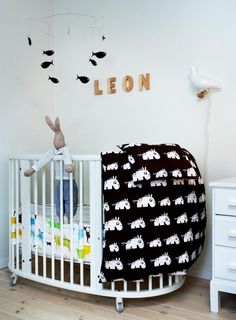 a baby crib with a black and white blanket on it