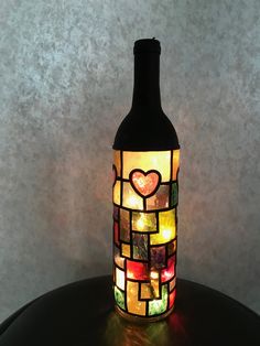 a bottle that is sitting on a table with a light in the shape of a heart