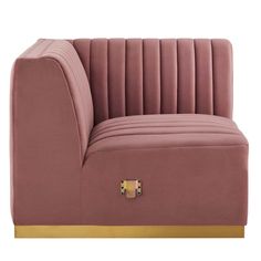 a pink velvet couch with gold trimmings and a button on the armrest