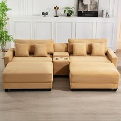 a living room with a couch, ottoman and coffee table in front of a white wall